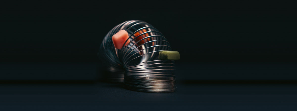 Vybrance Labs creatine gummies resting in a chrome spring coil on a dark studio background